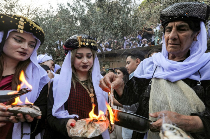 Iraqi Yazidis light candles during a ceremony marking the Yazidi New Year