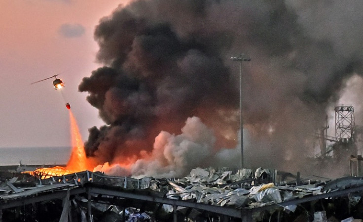 A helicopter fights the fire at the scene of an explosion at the port of Beirut on August 4, 2020