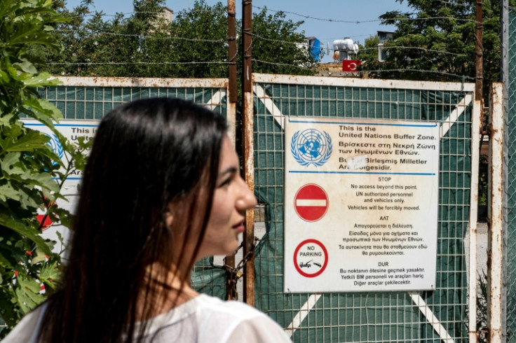 Tourism specialist Katerina Antoniou, in front of a gate to the UN-patrolled buffer zone, says urbex in Cyprus poses an 'ethical issue'