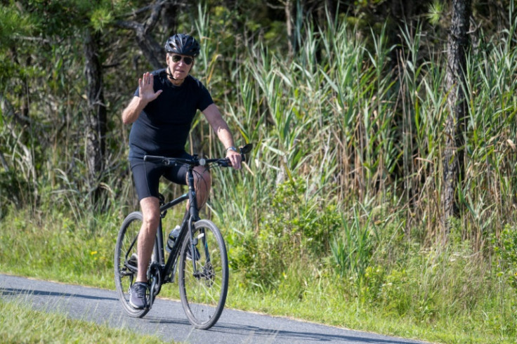 President Joe Biden, vacationing in Rehoboth Beach, Delaware, remained silent as he rode his bike past reporters who asked questions about his rival Donald Trump's legal woes