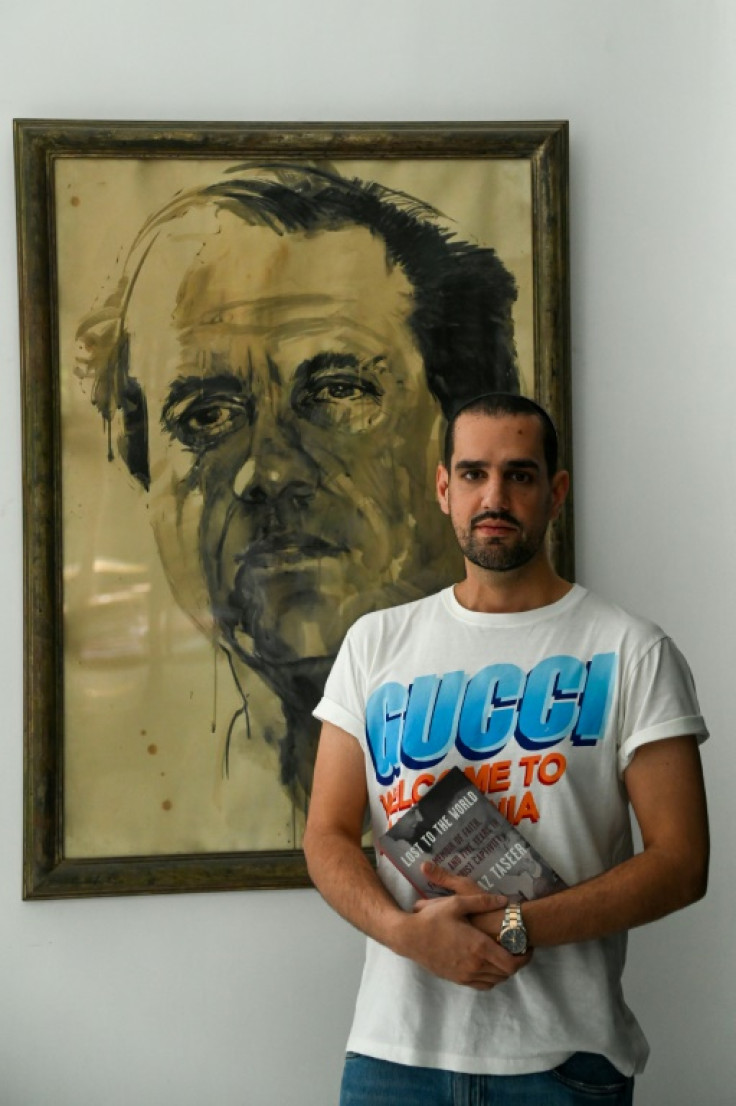 Shahbaz Taseer poses with a painting of his late father Salmaan, assassinated for supporting changes to Pakistan's blasphemy laws