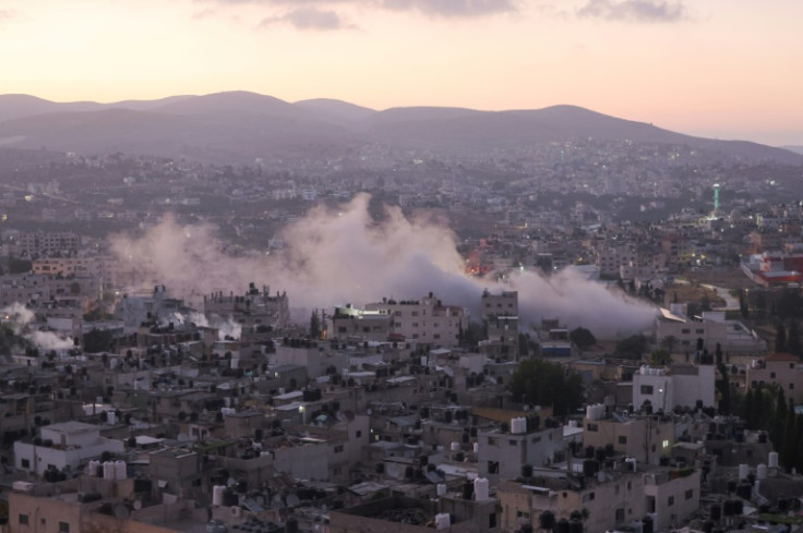 Smoke billows as Israeli soldiers demolish a house at the Askar camp for Palestinian refugees east of Nablus city in the occupied West Bank