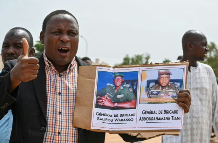 A supporter of the coup holds up a photo of new strongman General Abdourahamane Tiani at a rally in Niamey on Sunday
