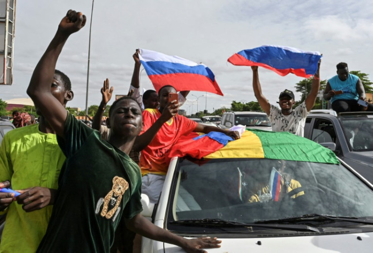 Supporters of Niger's military takeover wave Russian flags as they demonstrate in Niamey