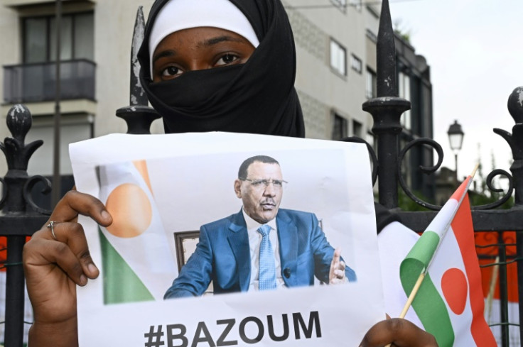 A woman holds an image of ousted Niger President Mohamed Bazoum during a protest outside the Niger Embassy in Paris