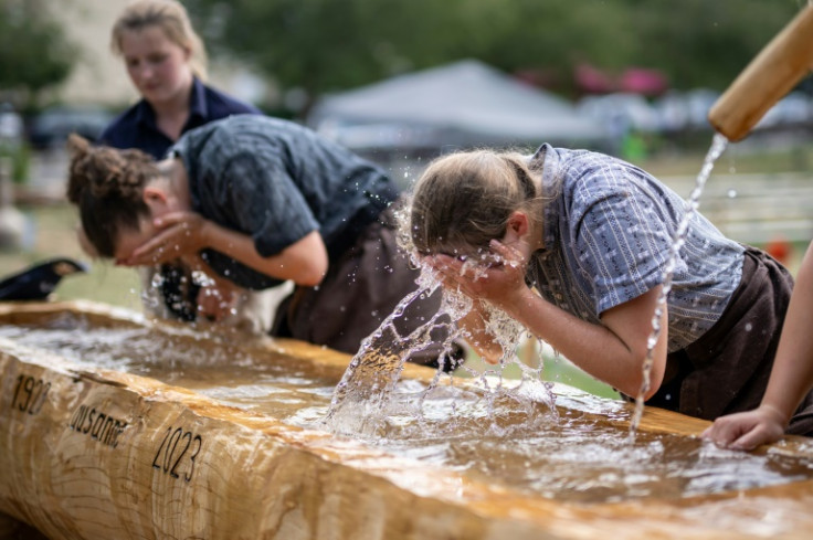 Wrestlers wash the sawdust from their faces after their bout