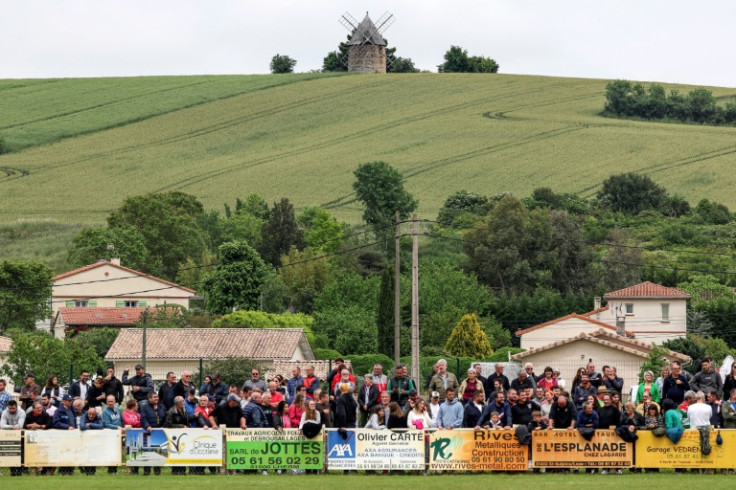 Supporters stand behind the barriers during the French Federale 1 rugby union match betwen Saint-Sulpice-sur-Leze and Valence d'Agen, at the Gaston-Sauret stadium in Saint-Sulpice-sur-Leze, southwestern France, on May 21, 2023. (Photo by Valentine CHAPUIS