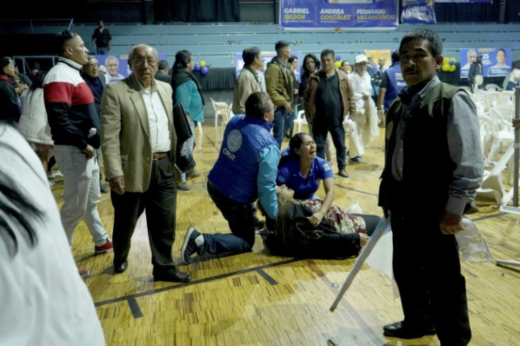 A woman is assisted after being wounded by shots fired during the assassination of presidential candidate Fernando Villavicencio after a rally in Quito