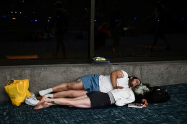 Passengers try to sleep on the floor of Kahului Airport  while waiting for delayed and canceled flights on August 9, 2023