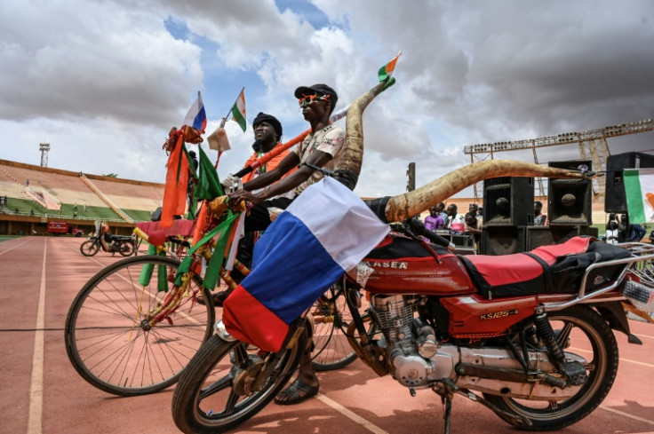 Coup supporters stand next to a motorbike at a concert at the General Seyni Kountche Stadium in Niamey on August 13, 2023
