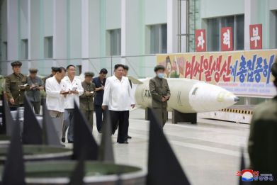 North Korean leader Kim Jong Un (C) called for increased missile production during visits to weapons factories, KCNA reported
