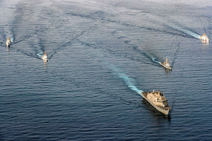 The US Navy's USS Sioux City and Coast Guard ships take part in an exercise while transiting the Strait of Hormuz in December