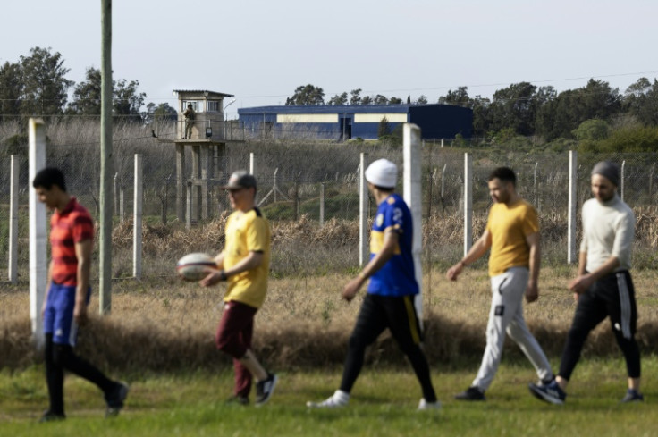 A prison guard looks on as inmates at a Montevideo prison take part in a rugby training session