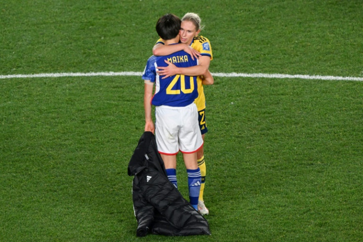 Sweden defender Jonna Andersson hugs Japan's Maika Hamano