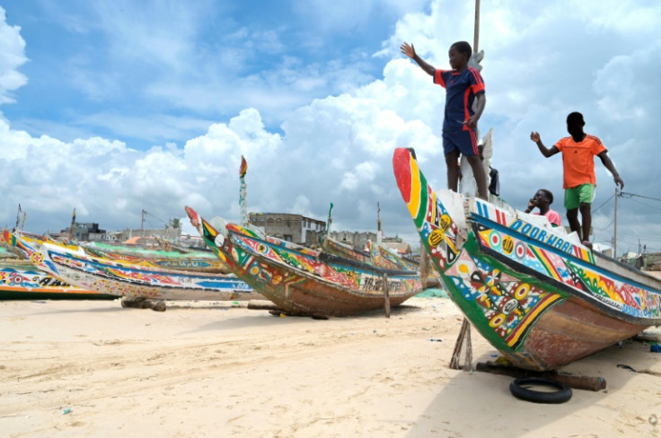 Young boys play on pirogues like the one that was found this week off Cape Verde with more than 60 passengers feared dead
