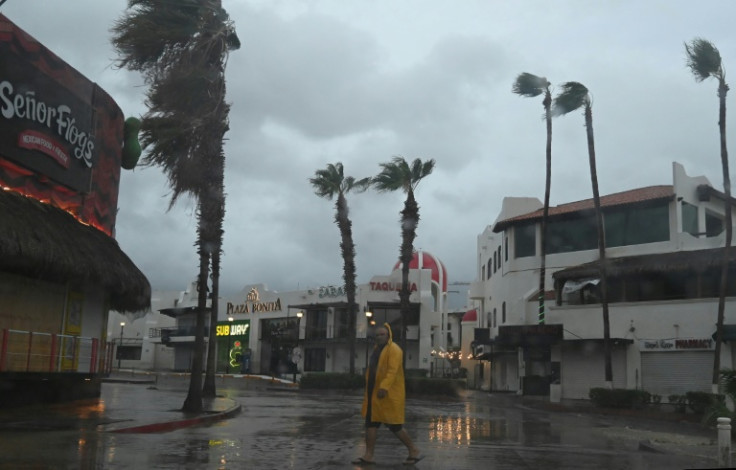 A man walks along a street in Cabo San Lucas, Mexico, as rain and wind gusts from Hurricane Hilary reach the area, on August 19, 2023