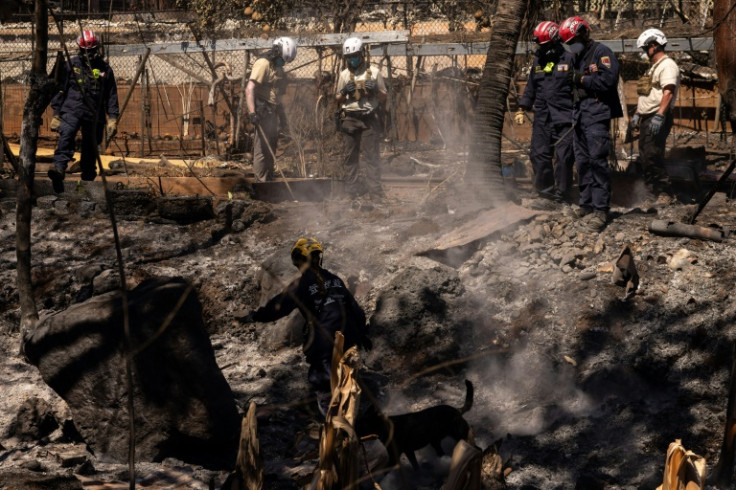 Search and recovery team members check charred buildings and cars in the aftermath of the Maui wildfires in Lahaina