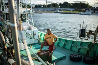 Fisherman Haruo Ono stands on one of his fishing boats. Japan's government will decide on Tuesday about the release of treated water from the crippled Fukushima nuclear plant nearby