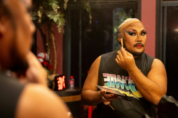 Convicts rugby player Marti Quinit works on his make-up backstage ahead of a fund-raising review