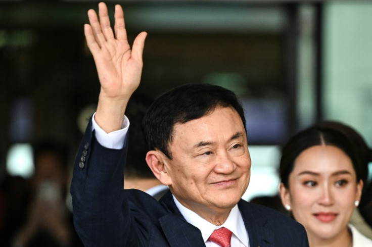 Former Thai Prime Minister Thaksin Shinawatra greets his supporters on Tuesday after returning from 15 years in exile