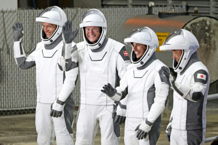 (From L) Konstantin Borisov, Andreas Mogensen, Jasmin Moghbeli and Satoshi Furukawa, wearing SpaceX spacesuits, wave before they depart for the ISS
