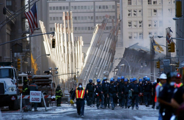 A team of rescue workers walk in front of the remains of the base of the World Trade Center in New York after the September 11, 2001 attacks
