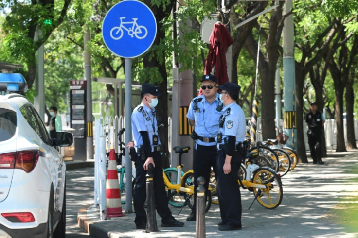 Police stand outside the Japanese embassy in Beijing after Japan's foreign ministry urged its citizens in China to be "cautious in your speech and behaviour. Do not speak Japanese unnecessarily or too loudly"