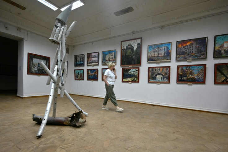 An employee walks past paintings displayed in a temporary exhibition at Kharkiv's damaged art museum