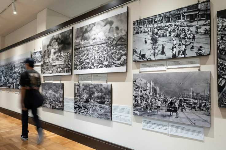 A visitor walkis past images on display from the 1923 earthquake and resulting fire which killed over 100,000 residents of Tokyo
