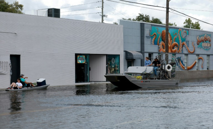 Kayakers and an airboat cruise down a flooded street after Hurricane Idalia passed offshore in Crystal River, Florida