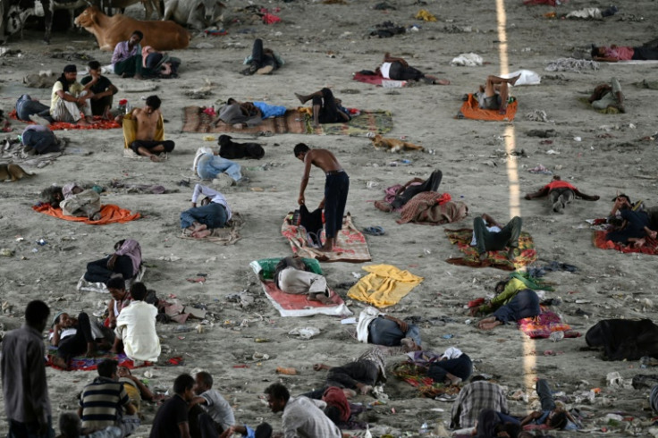Homeless people take rest under a bridge to get respite from the heat on a hot summer afternoon in New Delhi