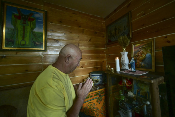 Khurts Lhamsuren prays in front of an altar at his house in Ulaanbaatar