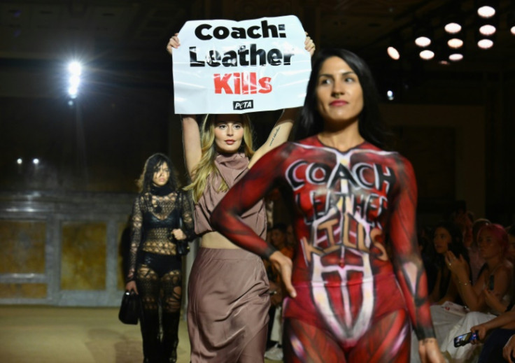 A an animal rights protestor holds a sign reading "Coach: Leather Kills" during New York Fashion Week
