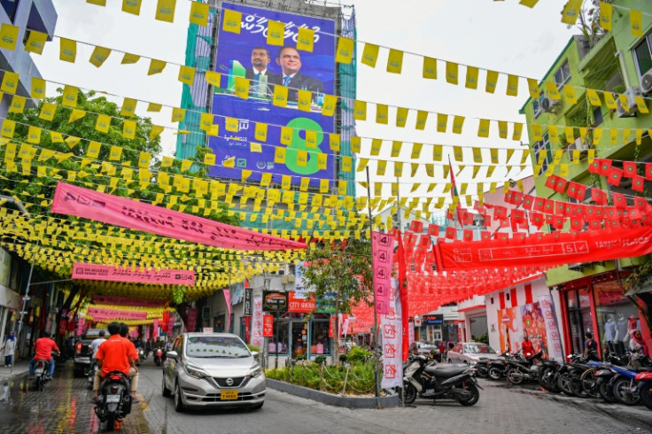 Commuters in the Maldives make their way along a street decorated ahead of the country's presidential election