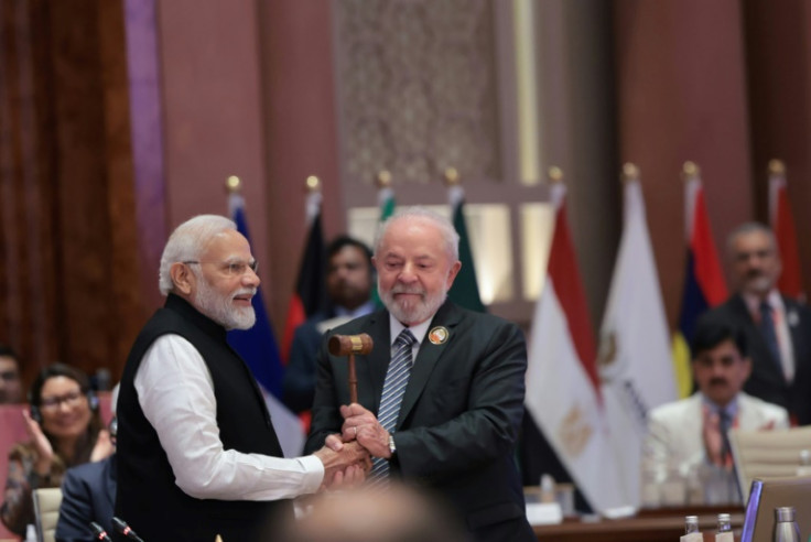 India's Prime Minister Narendra Modi (L) hands over the gavel to Brazil's President Luiz Inacio Lula da Silva (R) and the end of the G20 summit