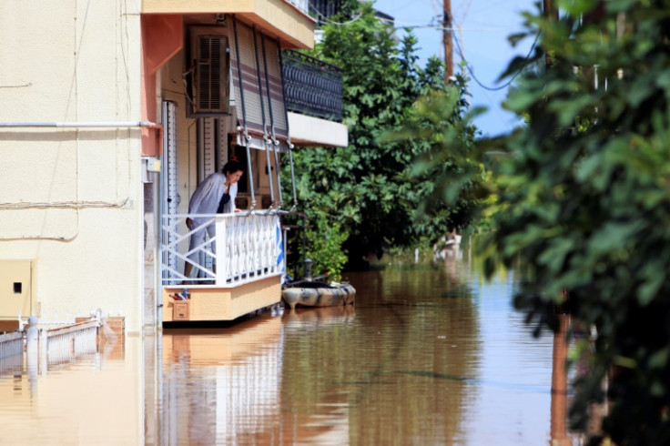 A woman looks out from her house in the flooded city of Larissa