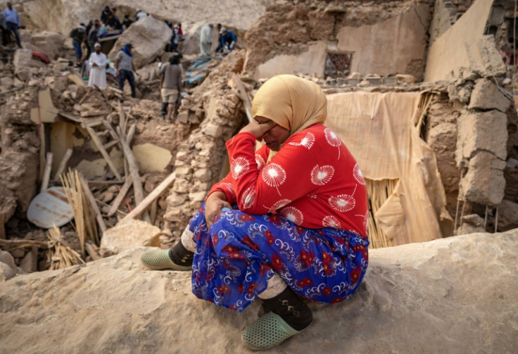 A woman reacts by the rubble of destroyed buildings