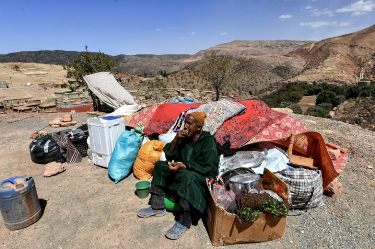 A man sits by salvaged items in the Moroccan village of Ighermane near Adassil, after the earthquake left survivors facing 'terrible conditions,' an aid volunteer said