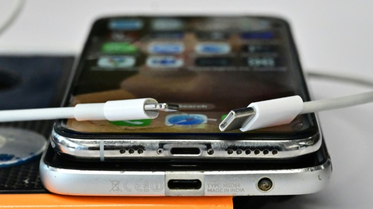 A USB-C charger (R) and a traditional Apple Lightning charger (L) are seen on an Apple iPhone
