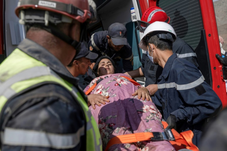 Rescue workers evacuate a survivor of the Morocco quake after they rescued her from under the rubble