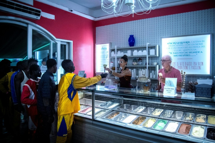 An Italian ice cream vendor offers ice creams to migrants