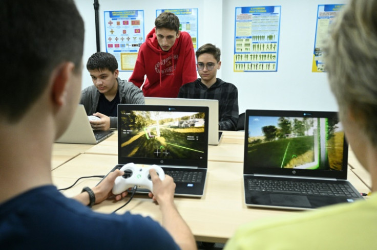 Boys learn to fly a drone using simulators during a lesson at a military-patriotic centre