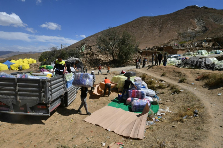 People unload a truck carrying aid in the earthquake-hit village of Ardouz