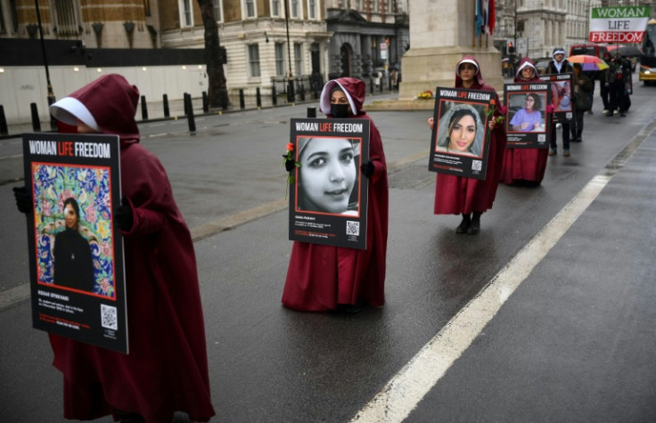 Demonstrators hold placards reading "Women, Life, Freedom" in support of Iranian women at a rally in central London on March 8, 2023