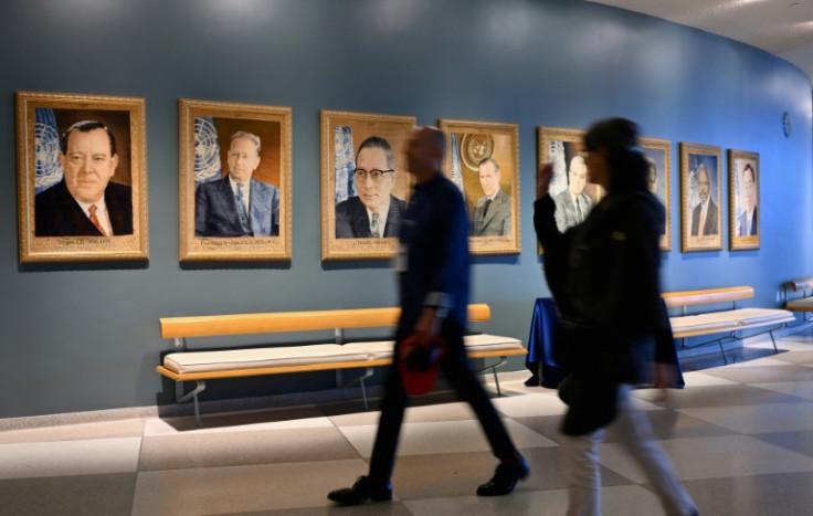 People walk past portraits of former UN secretaries-general at the United Nations headquarters ahead of the 78th session of the United Nations General Assembly