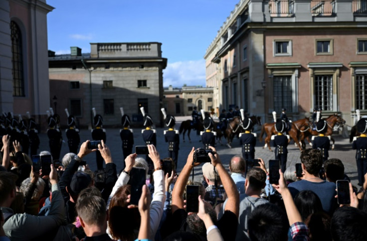 Spectators lift their mobile phones to get pictures of the royal couple