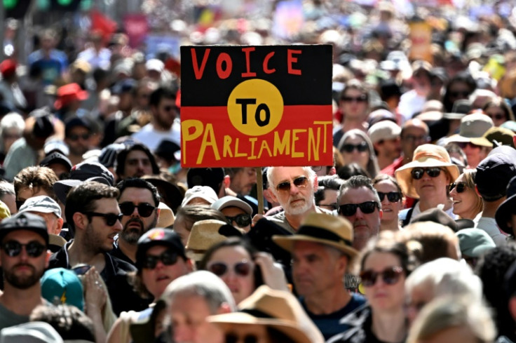 Crowds hold up a placard of the Australian Aboriginal Flag during a "Walk for Yes" rally in Melbourne