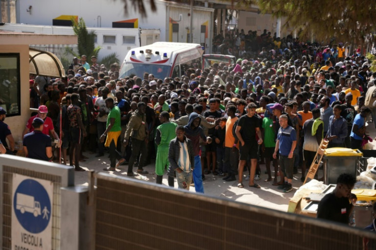 Migrants wait to receive registration papers from the Red Cross on the Italian island of Lampedusa