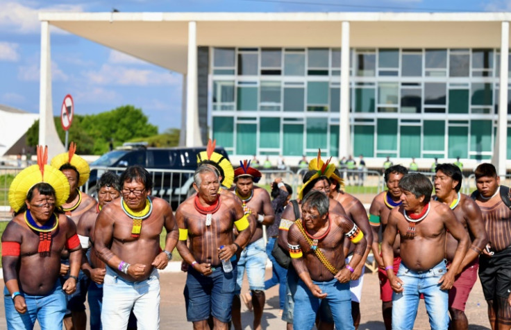 Brazilian Indigenous men outside the Supreme Court in Brasilia celebrate as the court rule against efforts to restrict native peoples' rights to reservations on their ancestral lands