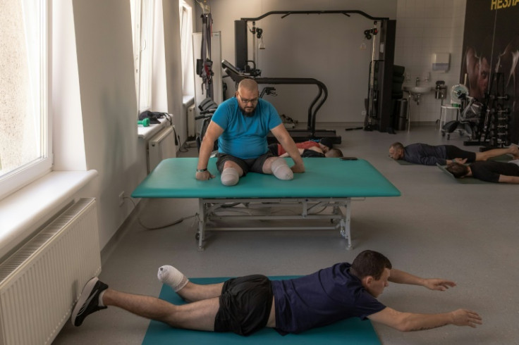 A Ukrainian soldier, who has lost both legs, rests during a physiotherapy session